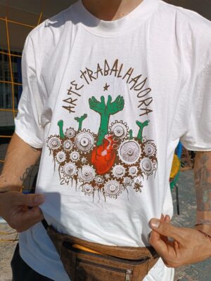 Camiseta com estampa Arte Trabalhadora coração vermelho brotando 2 mãos no meio de engrenagens que o espremem.